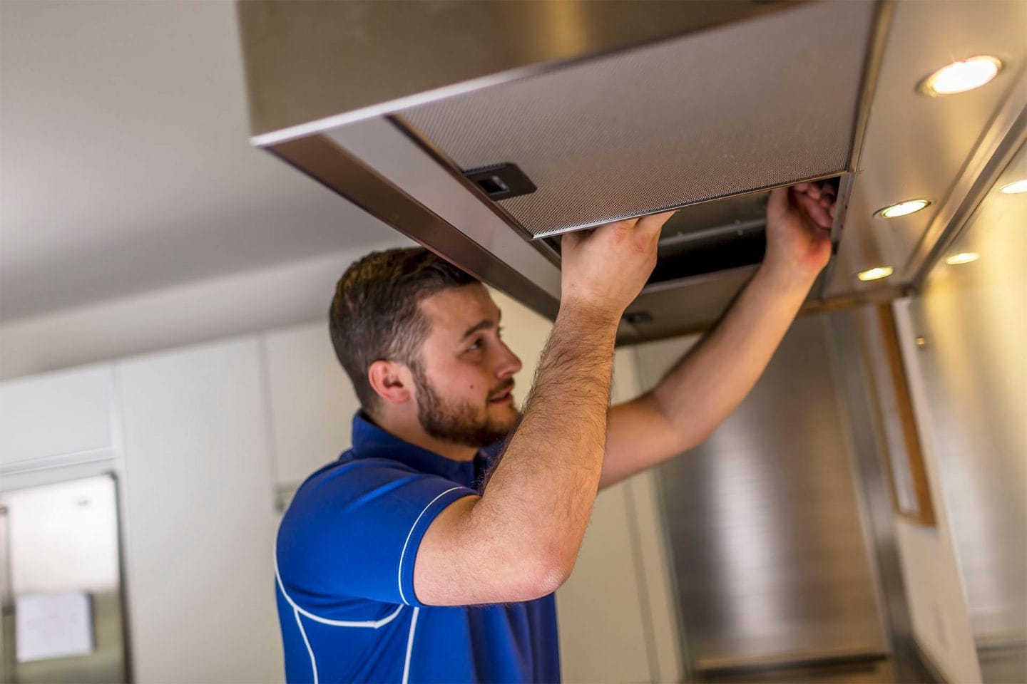 Kitchen hood installer carrying out canopy installation in Cheltenham